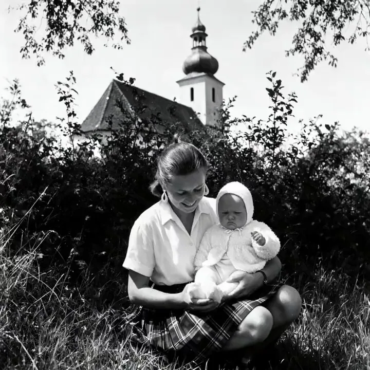 Ożywione zdjęcie: mama z niemowlęciem na łące przed wiejskim kościołem